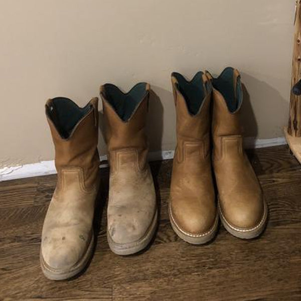 Pair of brown work boots with green lining on a wooden floor.