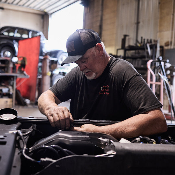 Man working on a car engine in a garage