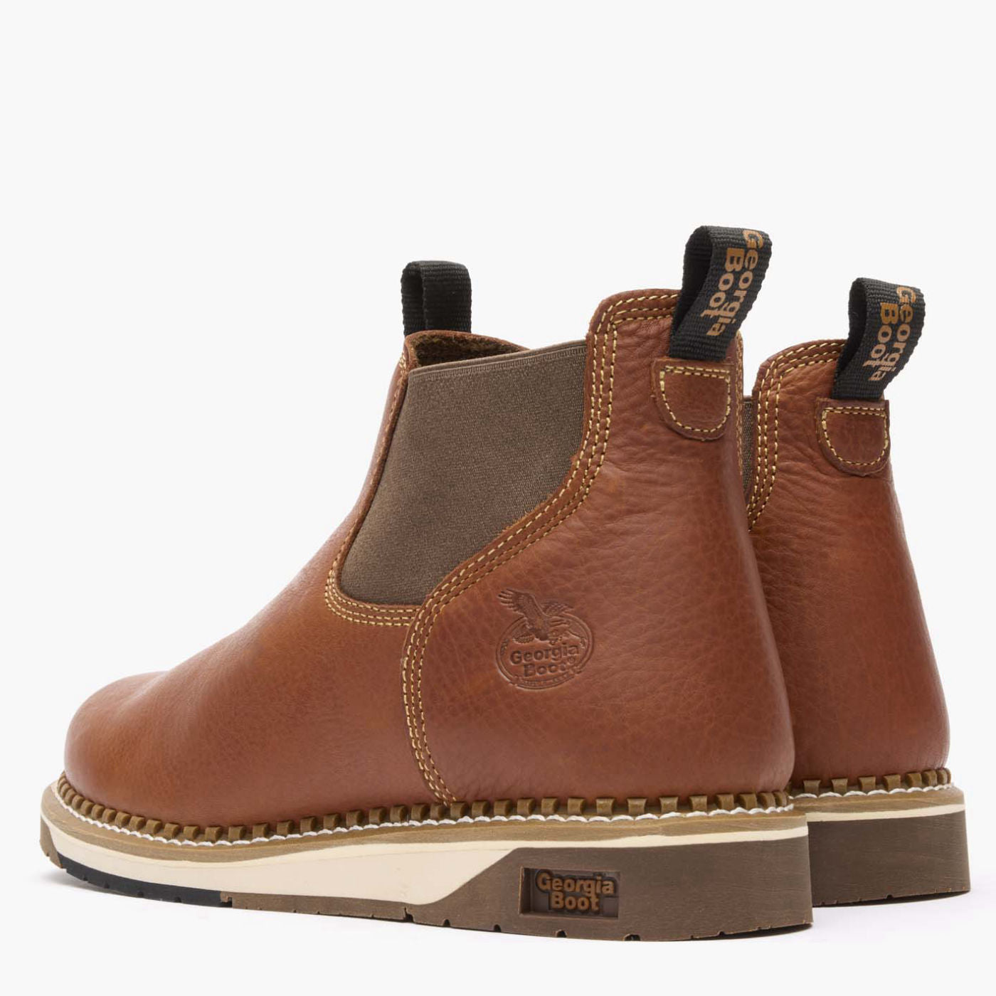 Pair of brown leather boots with visible brand logo on a white background