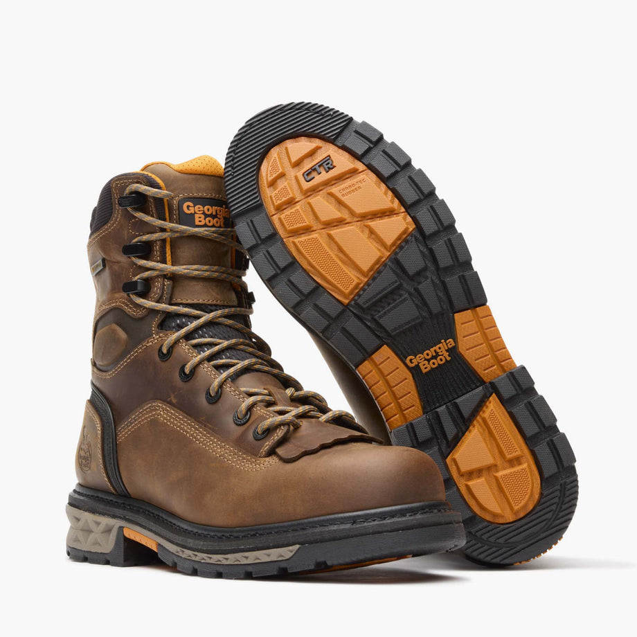 Brown work boot with orange and black sole on a white background