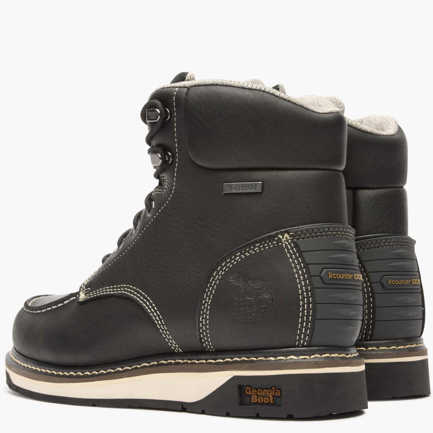 Pair of black leather boots with white soles on a white background