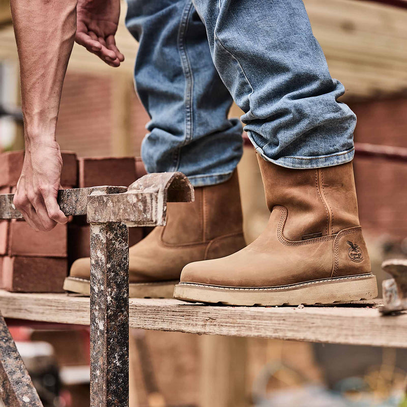 Person wearing brown work boots on a construction site