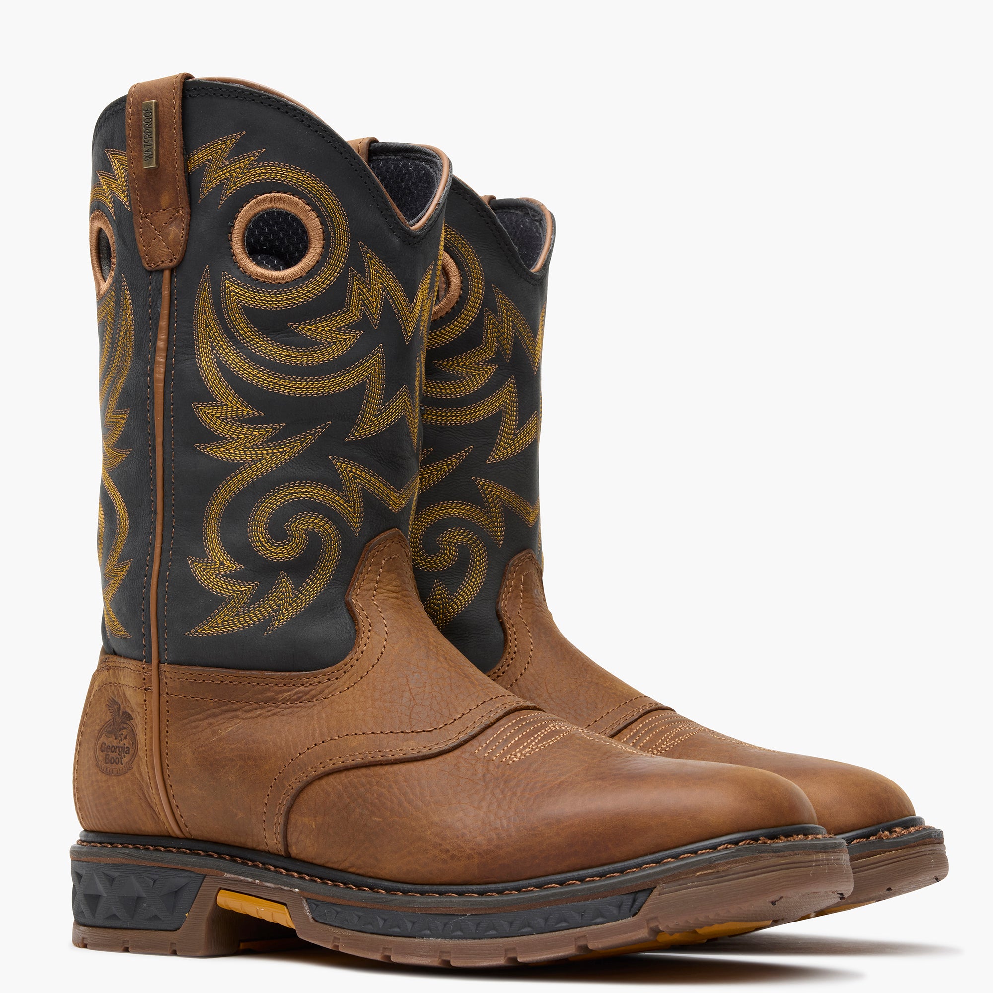 Pair of brown and black cowboy boots with intricate patterns on a white background